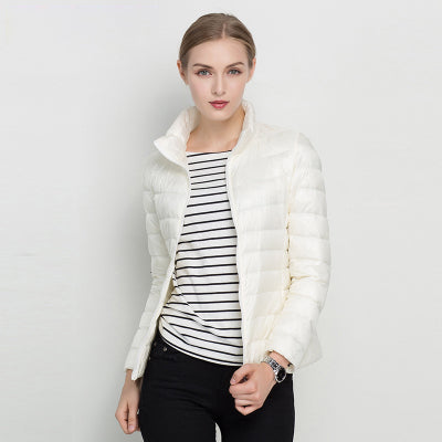 Modern women's sleek puffer jacket, quilted for warmth, featuring a stand collar & full zip. Great fall outerwear.