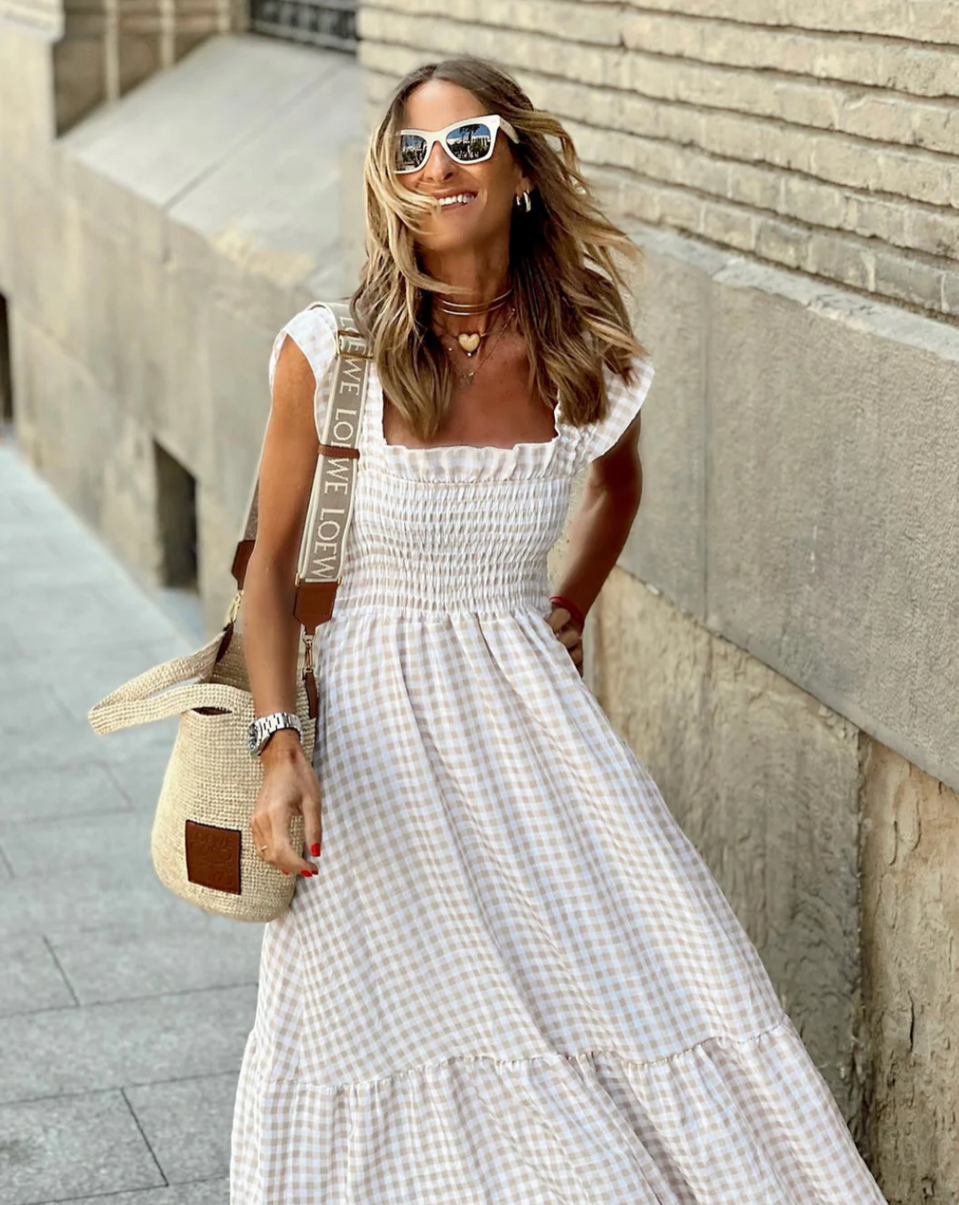 Chic gingham maxi dress for women, featuring a smocked bodice and pretty ruffle sleeves. Long, elegant summer fashion.