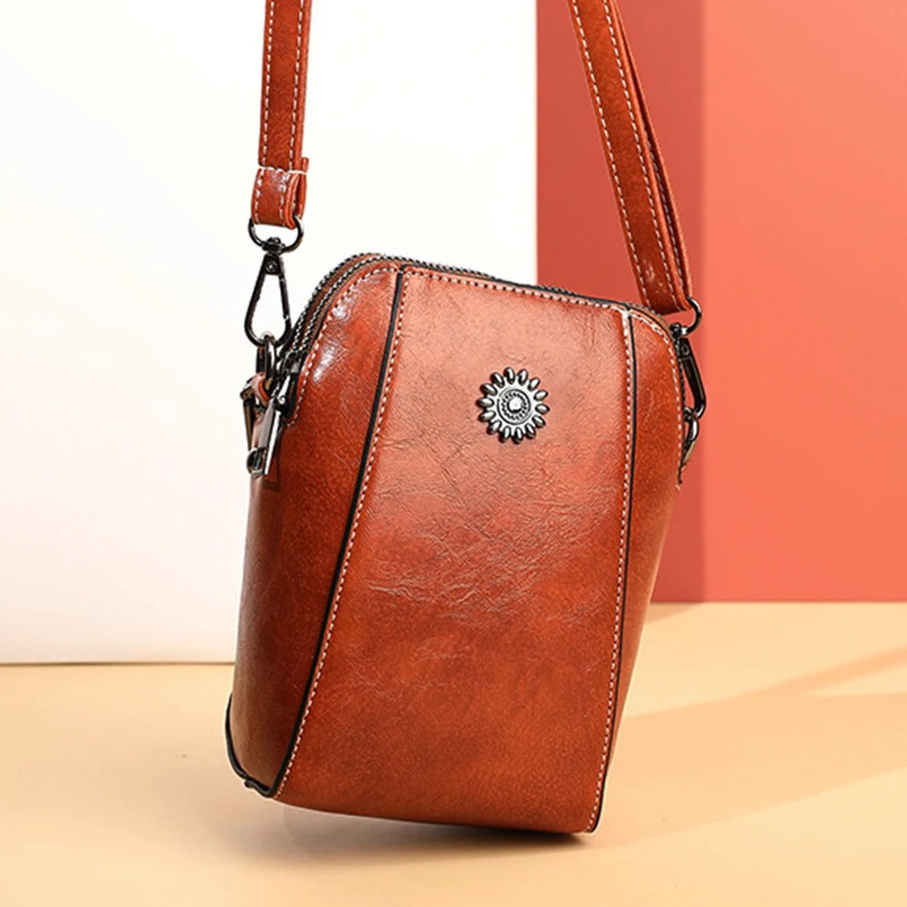 Stylish women's versatile red leather handbag, an elegant accessory with a convenient adjustable strap.