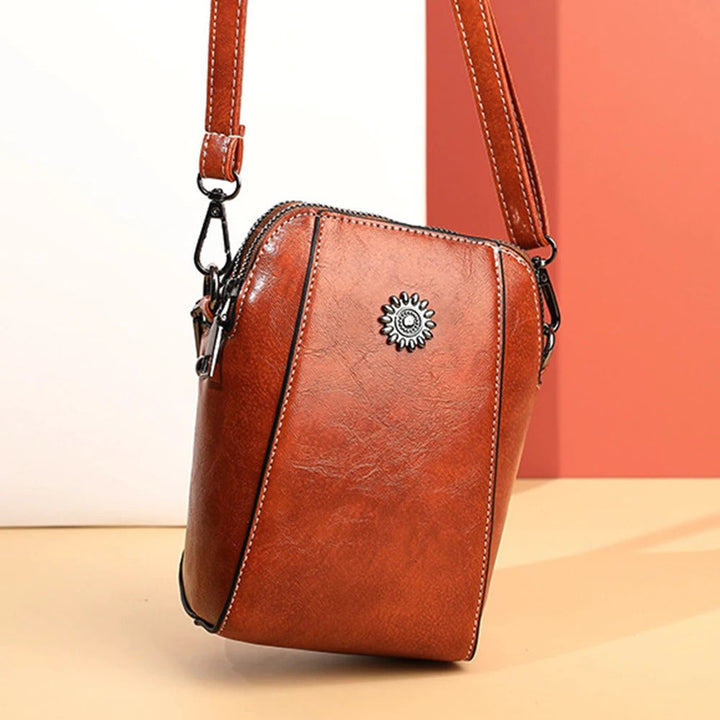 Stylish women's versatile red leather handbag, an elegant accessory with a convenient adjustable strap.