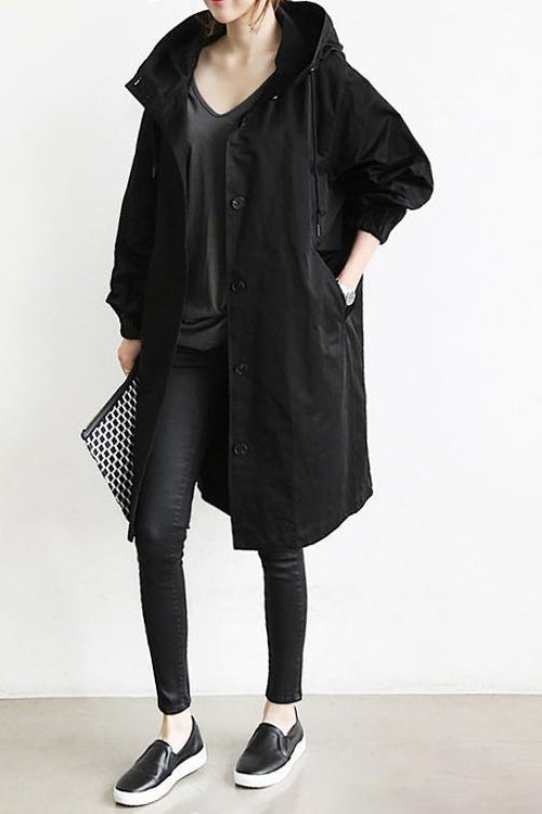 Model wearing a women's hooded waterproof trench coat. Lightweight, stylish & versatile for everyday.