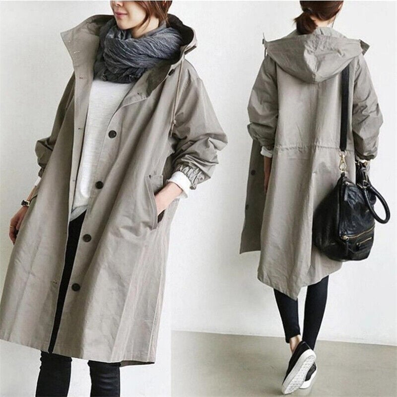 Side view of a women's long hooded waterproof trench coat. Stylish, lightweight, perfect for travel & rain.