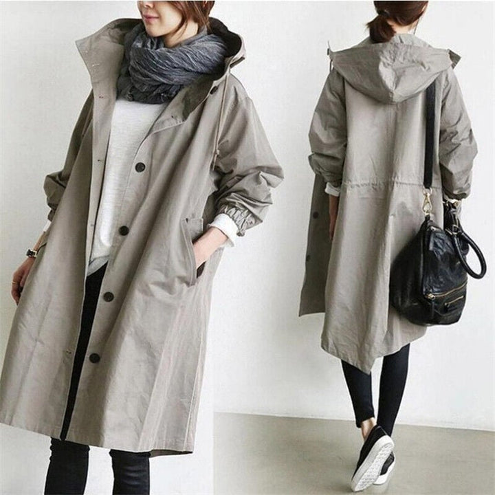 Side view of a women's long hooded waterproof trench coat. Stylish, lightweight, perfect for travel & rain.