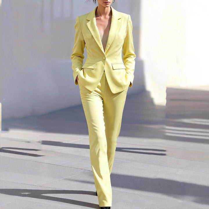 Women's tailored yellow two-piece suit: a stylish blazer & trousers set for professional workwear attire.