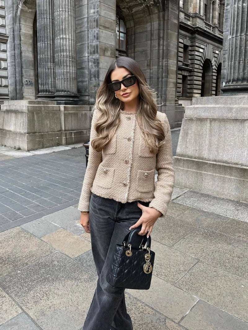 Classic women's tweed blazer with luxurious gold buttons. Elegant outerwear for a sophisticated, timeless look.