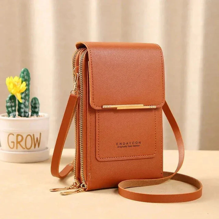 Hands-free women's shoulder bag, featuring a clear touch screen window for smartphone operation & security.