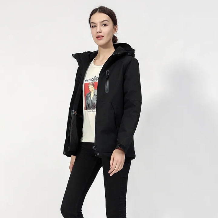 Woman wearing a black hooded USB heated jacket, suitable for hiking & active outdoor use.