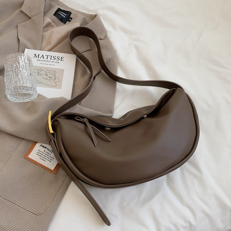 Stylish women's half-moon crossbody bag in vegan leather, featuring an adjustable shoulder strap for versatile wear.