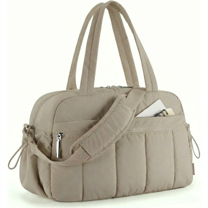 Black women's duffle bag, ideal for gym, travel, and work. Features a practical pocket, functions as a shoulder or carryall bag.