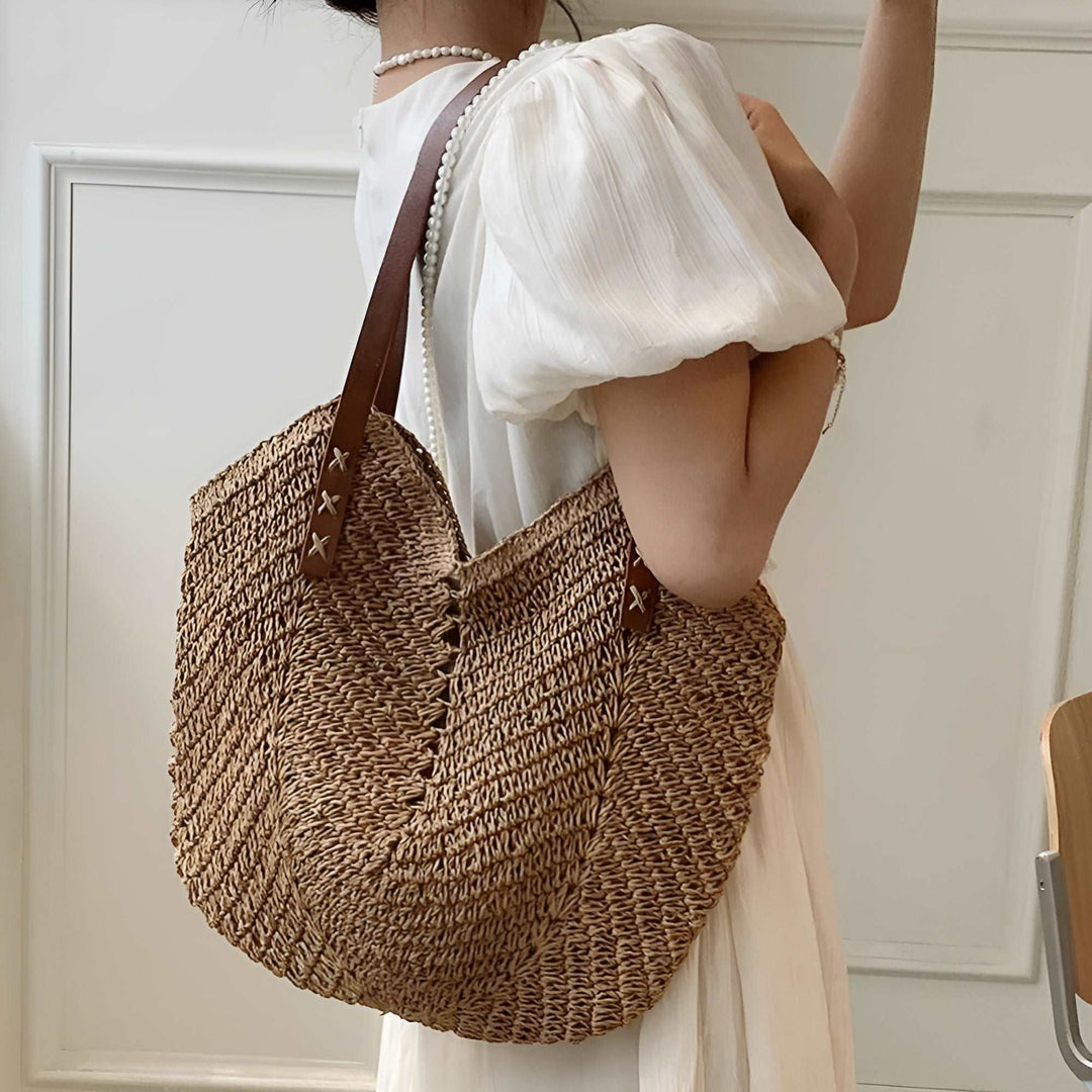 Women's woven beach tote bag in natural straw, perfect for summer vacations & casual outings. Stylish shoulder carryall.