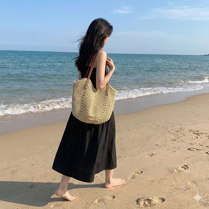 Natural woven straw beach tote bag for women, featuring a spacious design & comfortable shoulder straps. Summer essential.