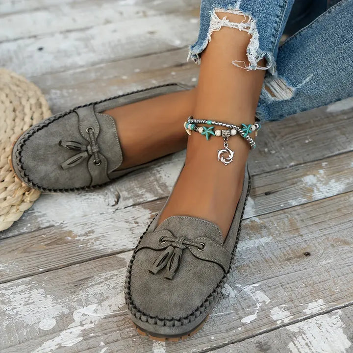 "Women's classic bow loafers in soft suede, stylish flat slip-ons with elegant bow accent, ideal for any occasion."
