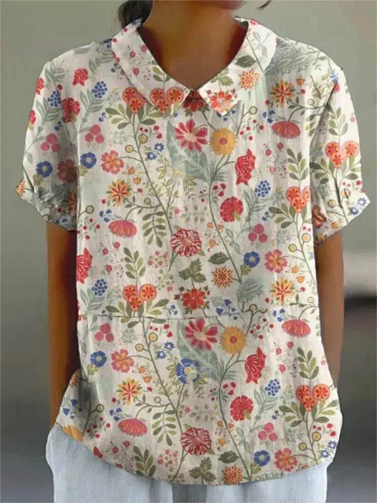 Women's elegant floral blouse with short sleeves and Peter Pan collar, featuring a vibrant floral pattern for stylish summer 