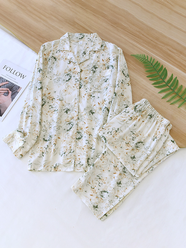 Women's luxurious cotton long-sleeve pyjama set, soft breathable fabric, elegant two-piece design in light pastel colors.