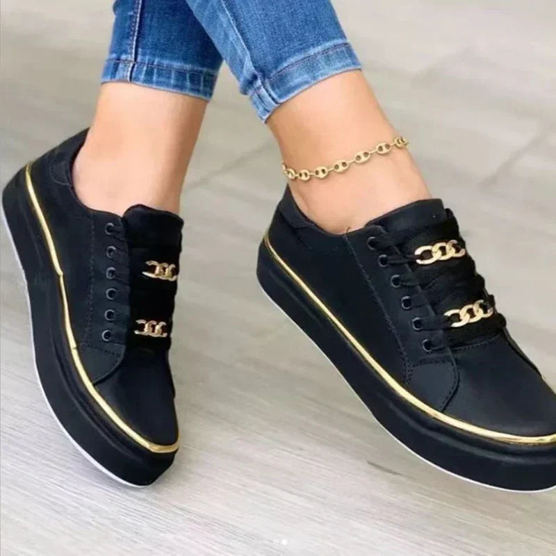 Women's platform sneakers with bold gold chain, round toe, and lace-up closure; stylish design suitable for all seasons.