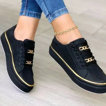 Women's platform sneakers with bold gold chain, round toe, and lace-up closure; stylish design suitable for all seasons.