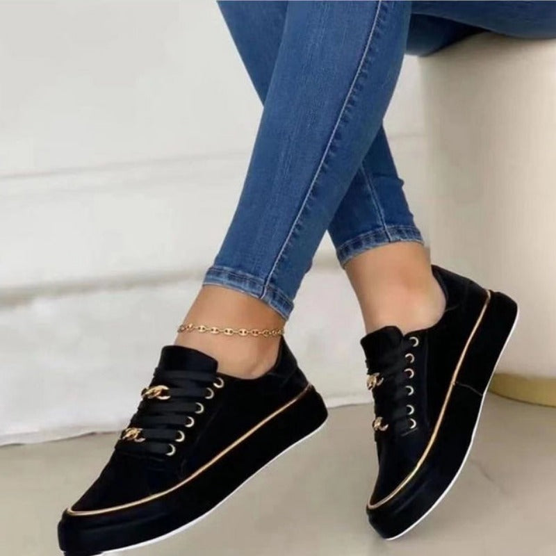 Women's platform sneakers with bold gold chain, round toe, and lace-up closure; stylish design suitable for all seasons.