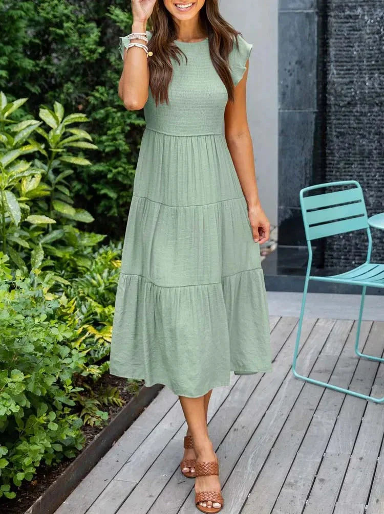 Women's sleeveless smocked midi dress with A-line skirt, airy fabric, perfect for summer occasions. Elegant and comfortable.