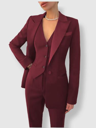 Women's tailored suit with notch lapels, blazer with button closure, and matching trousers in a polished formal style.