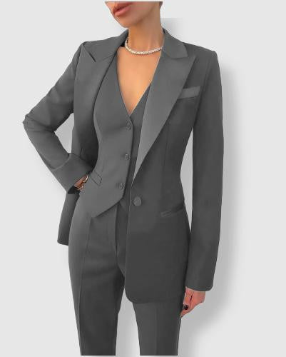 Women's tailored suit with notch lapels, blazer with button closure, and matching trousers in a polished formal style.