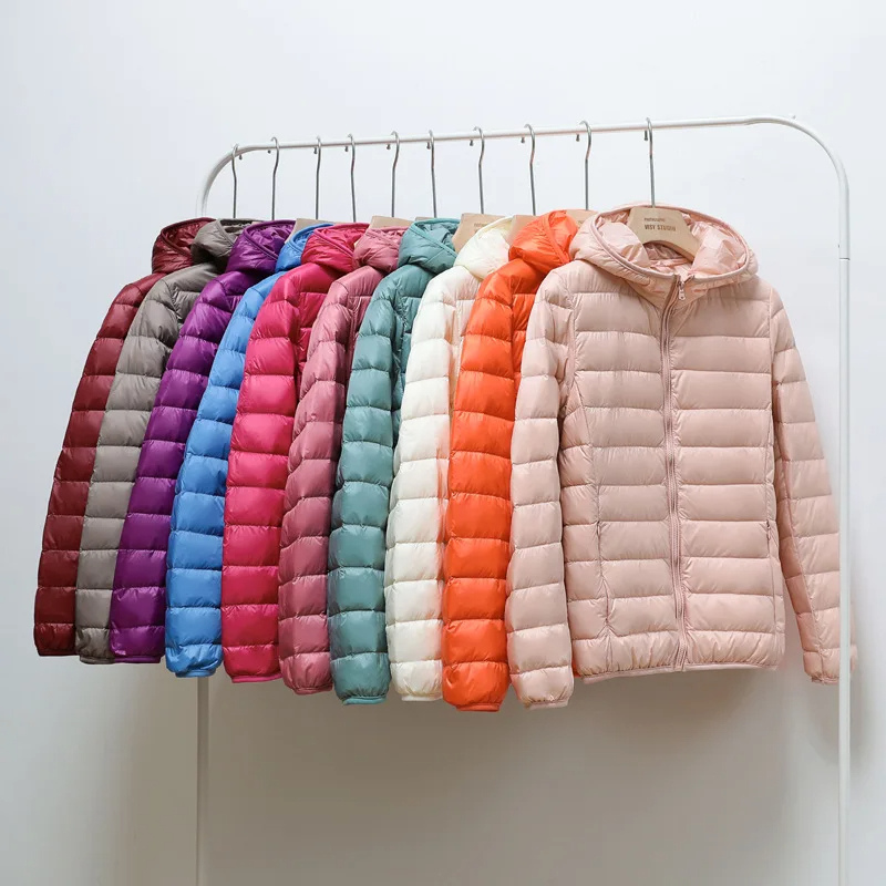 "Women's ultralight foldable puffer jacket with hood, chic design, lightweight, perfect for travel and cold weather."