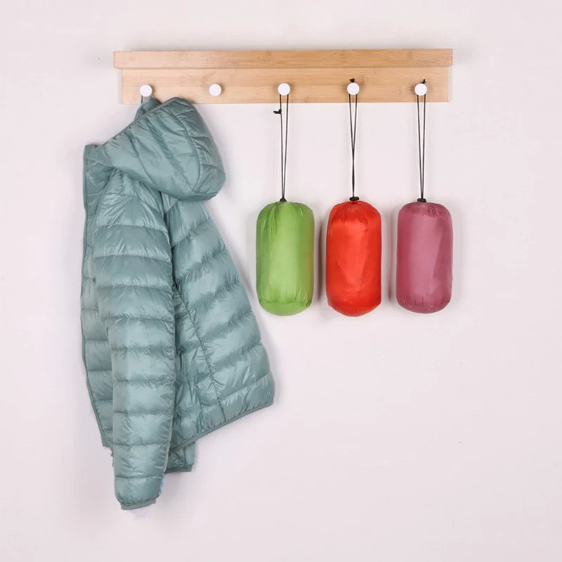 "Women's ultralight foldable puffer jacket with hood, chic design, lightweight, perfect for travel and cold weather."