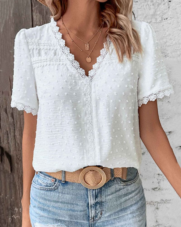 "Women's white textured V-neck summer blouse with lace trim and lightweight fabric, perfect for casual warm-weather outings."