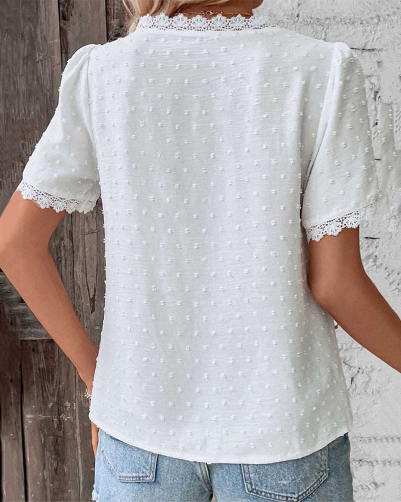 "Women's white textured V-neck summer blouse with lace trim and lightweight fabric, perfect for casual warm-weather outings."