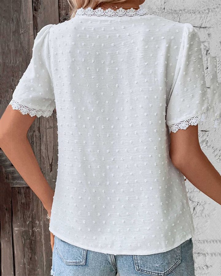 "Women's white textured V-neck summer blouse with lace trim and lightweight fabric, perfect for casual warm-weather outings."