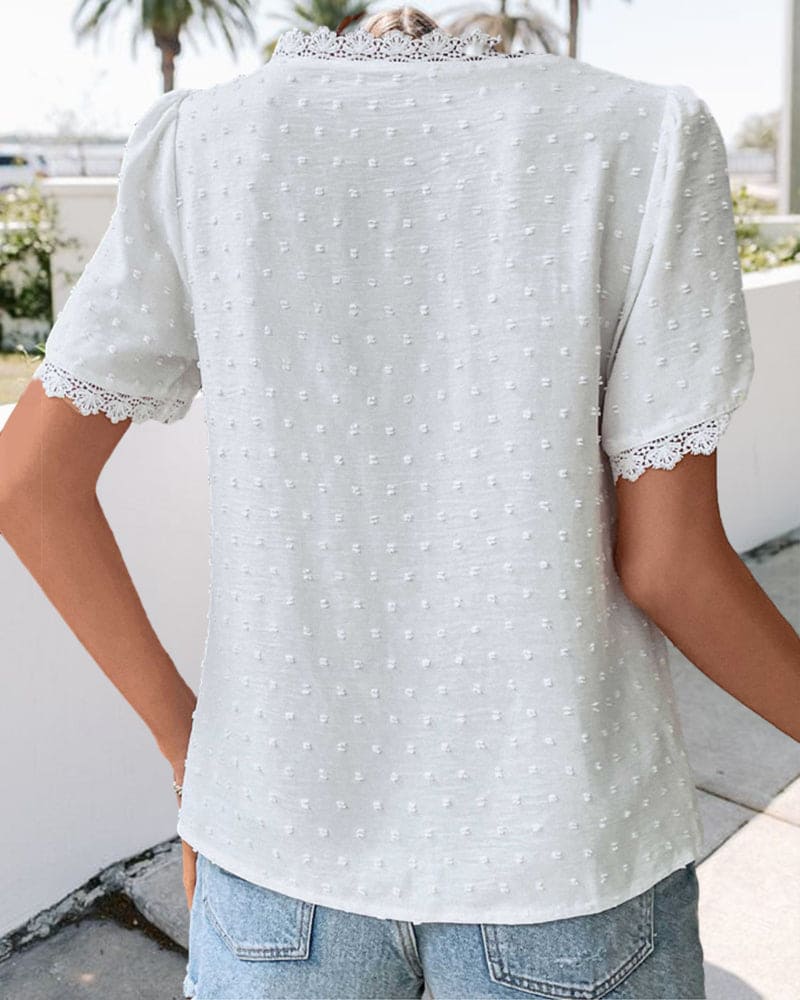 "Women's white textured V-neck summer blouse with lace trim and lightweight fabric, perfect for casual warm-weather outings."