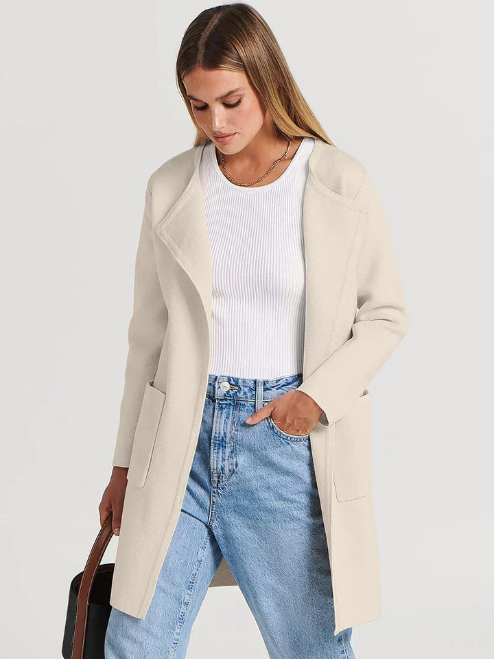 "Women's wool blend knee-length coat with wide lapel and patch pockets, showcasing a relaxed fit and minimalist design."