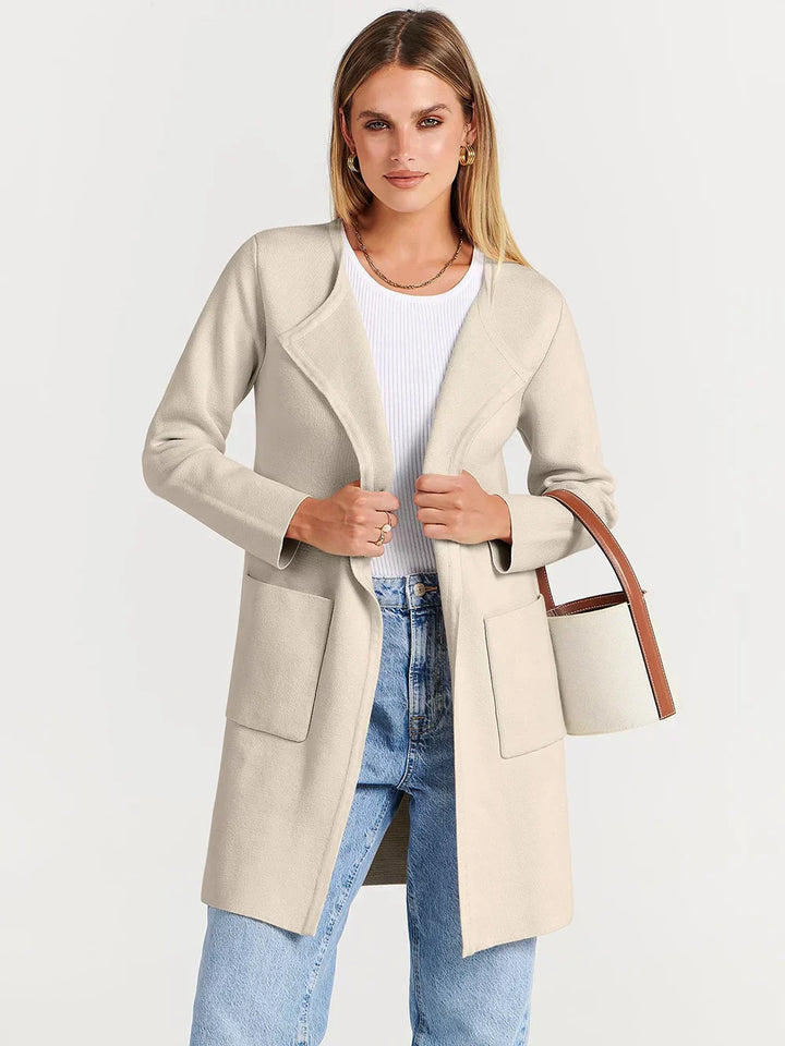 "Women's wool blend knee-length coat with wide lapel and patch pockets, showcasing a relaxed fit and minimalist design."