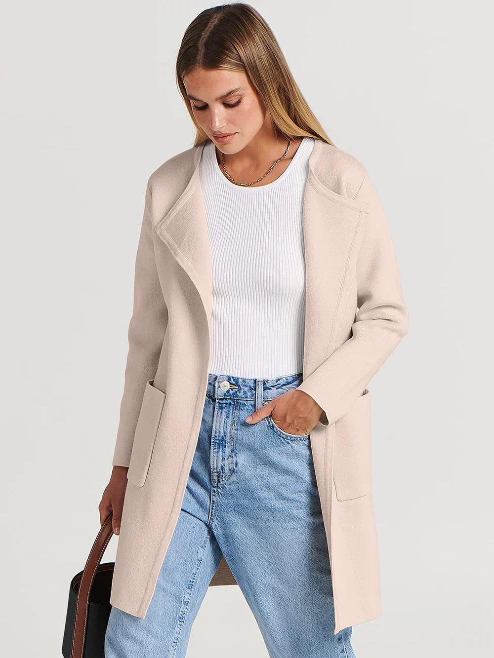 "Women's wool blend knee-length coat with wide lapel and patch pockets, showcasing a relaxed fit and minimalist design."