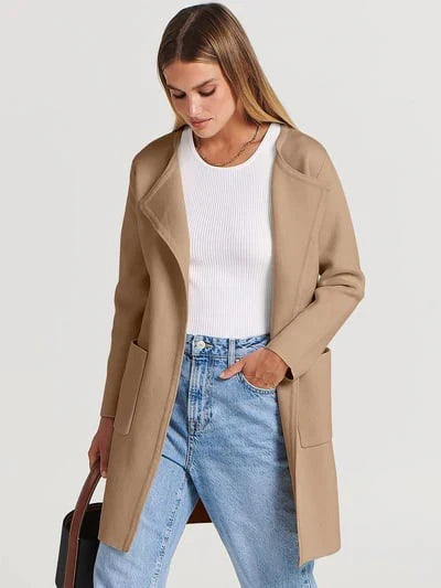 "Women's wool blend knee-length coat with wide lapel and patch pockets, showcasing a relaxed fit and minimalist design."