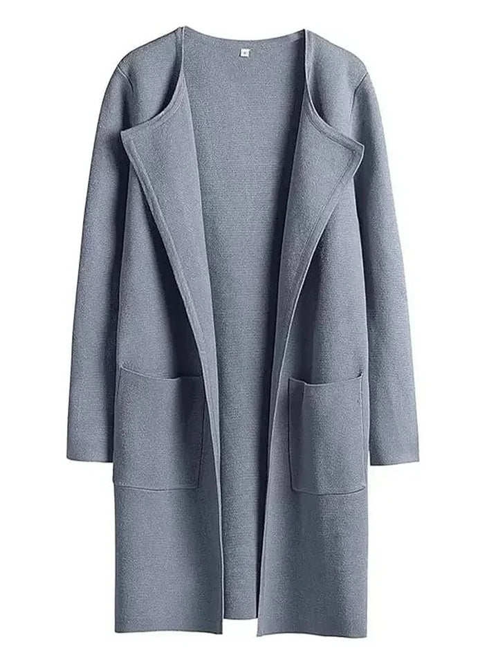 "Women's wool blend knee-length coat with wide lapel and patch pockets, showcasing a relaxed fit and minimalist design."